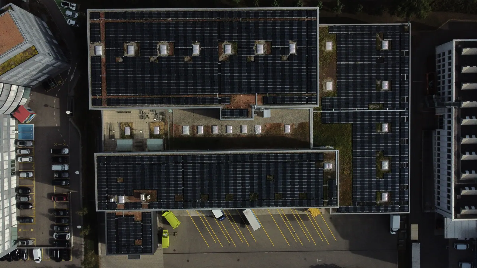 Drohnenaufnahme von oben: Logistikbau, die Flachdächer fast vollständig mit Photovoltaik belegt