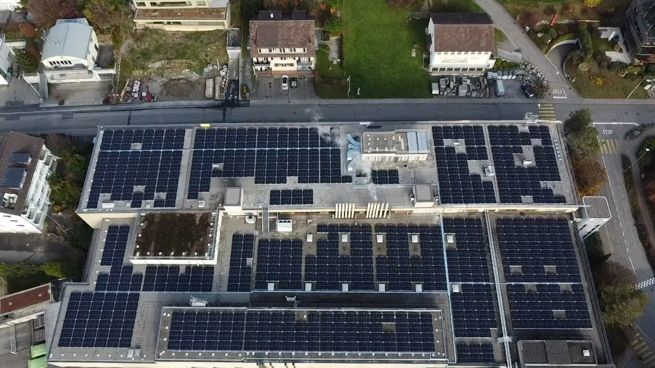 Drohnenaufnahme von oben: Industriebau mit Photovoltaik auf mehreren Flachdächern