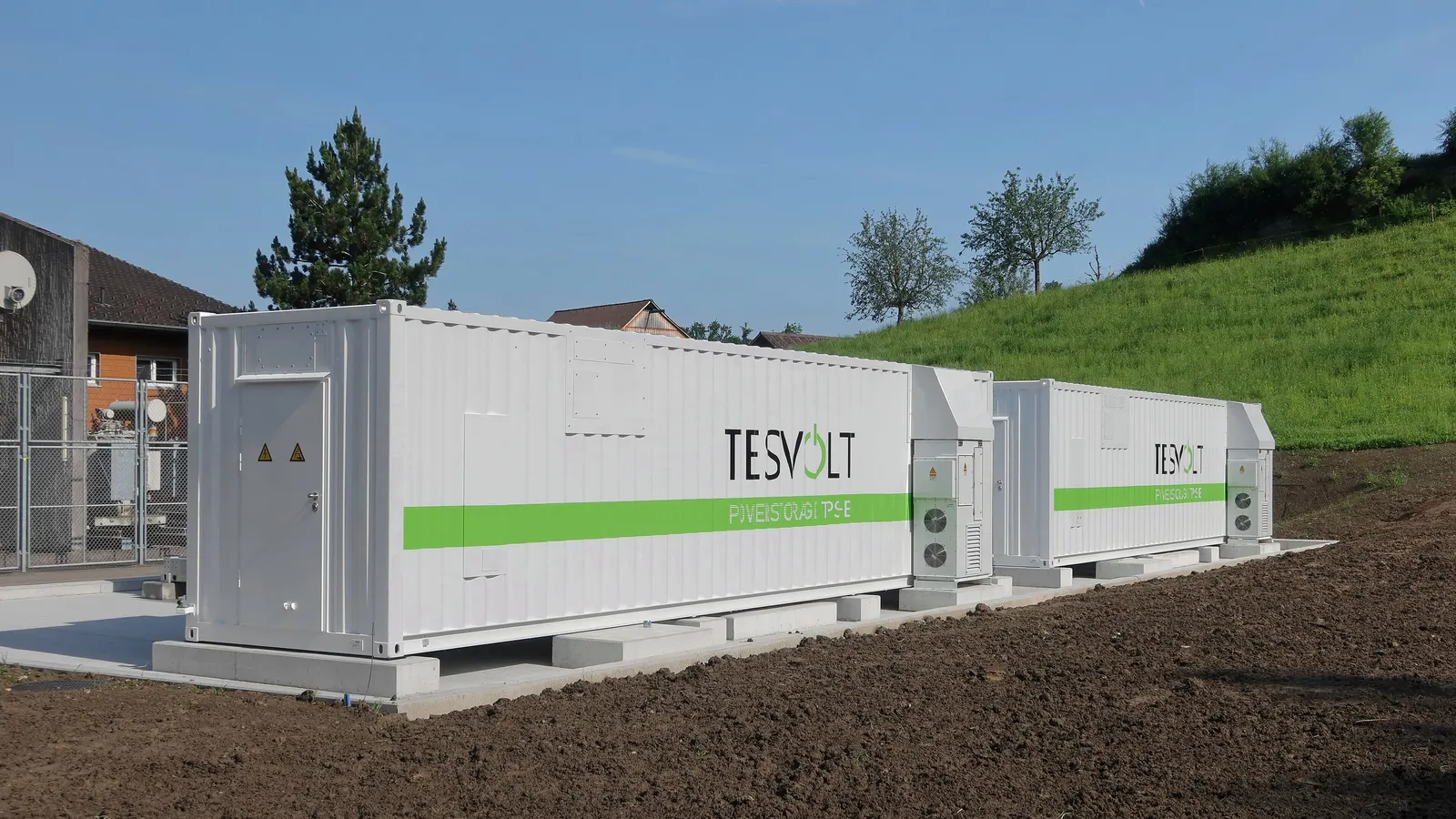 Batteriespeicher in Containerbauweise neben einem Gewerbegebäude