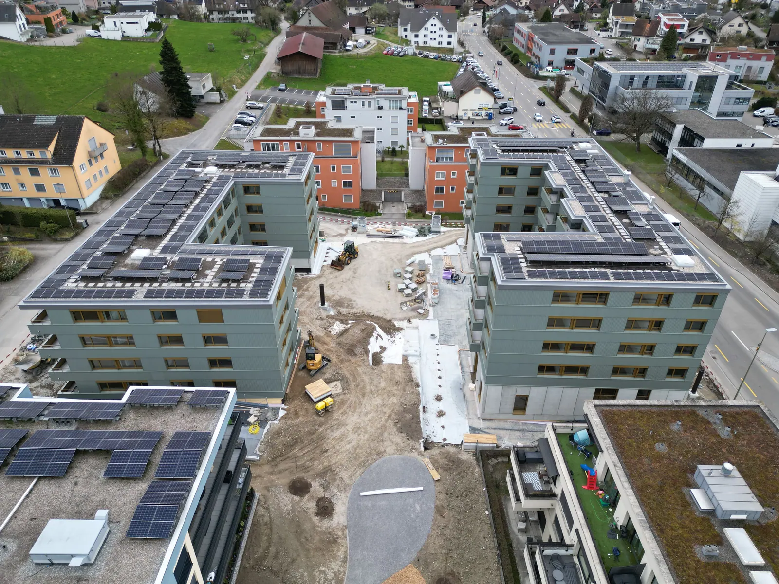 Drohnenaufnahme aus der Bauphase: Neubau mit Baustelleneinrichtung und Photovoltaik auf dem Dach